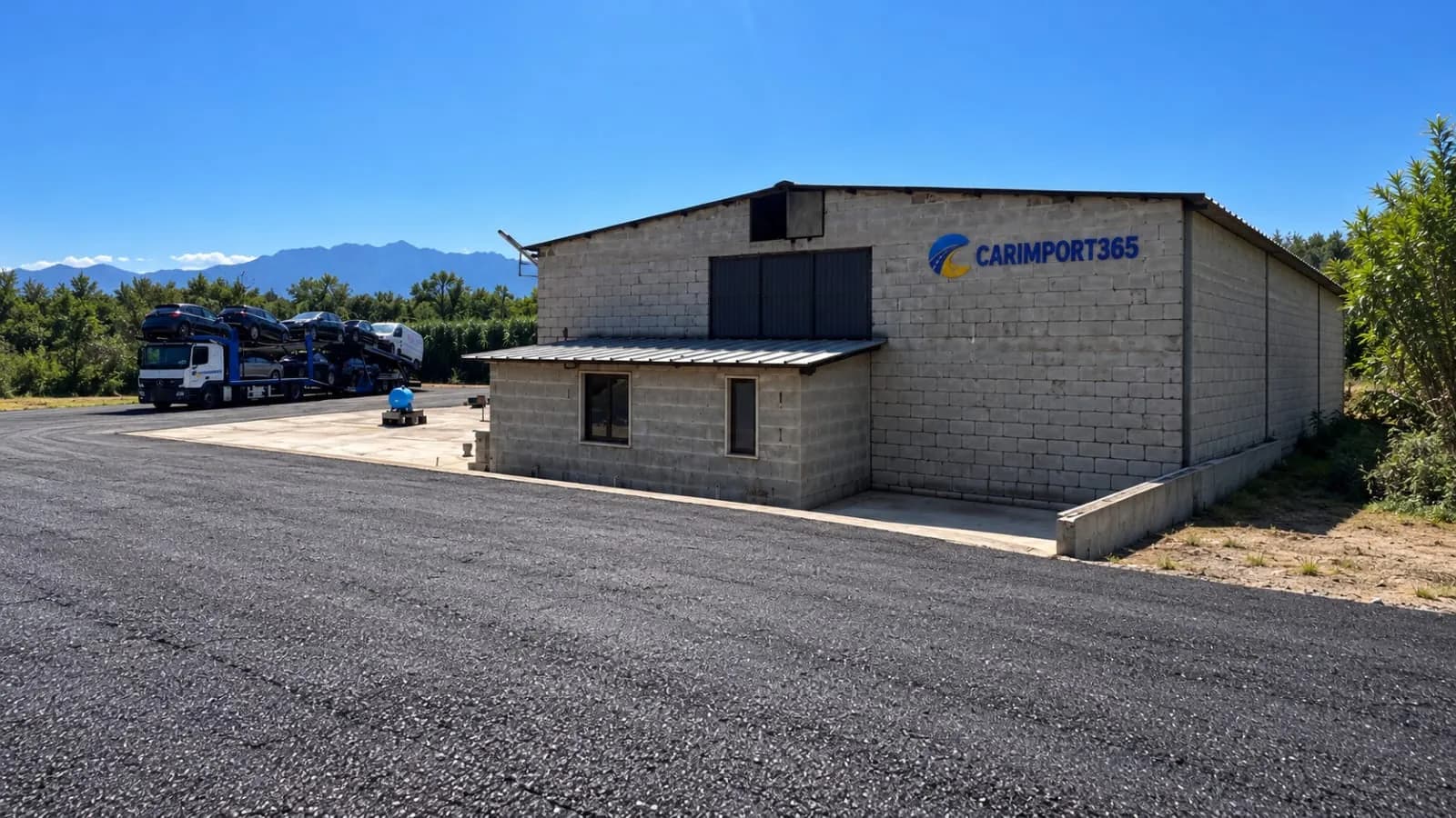 Базата на Carimport365 в Италия: складова сграда с надпис Carimport365 и автовоз с коли в двора